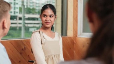 Genç öğrenci toplantıda veya grup tartışmasında diğer öğrencileri dinlerken gülümsüyor. Tecrübelerinden ve karışık ırktan arkadaşlarıyla paylaştığından bahseden sevimli bir genç. Yaratıcı eğitim. Öğretim