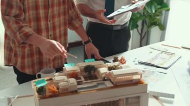 Akıllı mimar ya da inşaat mühendisi bina yapısı fikrini not edip plana yapıştırıyor. Yöneticinin çeşitli meslektaşları ve ev planlarıyla birlikte çalıştığı hava görüşü. Hizalama.