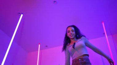 Latin dansçıların kameraya bakıp şehrin pop müziğiyle dans ettiği düşük açılı kamera. Profesyonel çekici hipster, mor veya neon ışıklı hip hop şarkısına geçiyor. Şık bir kumaş. Mutluluk.