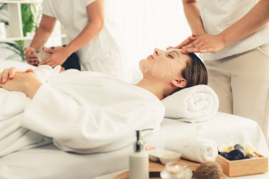 Kaplıca salonunun sakin, modern gündüz atmosferi, birkaç müşteri yüz maskesi takarak kendini yenilemeye çalışıyor. Yüz bakımı ve güzellik kozmetolojisi prosedürü. Sessiz.