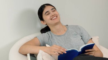 Kanepede oturan orta yaşlı bir kadın, sosyal ve teknolojik mesleki gelişmeler hakkında ders kitabı okur ya da zeki bir anne olmak için çocuk yetiştirir. Hayat boyu öğrenme konsepti. Uyumsuzluk.