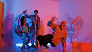 Stüdyoda gündelik kıyafetleri olan çok kültürlü bir arkadaş tezahürat yaparken mutlu hipster break dansları. Profesyonel sokak dansçısı hip hop ritmi ya da neon veya kurşun ışıkla kafiyeli bir şarkı söyler. Mutluluk.