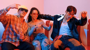 Mutlu kız kameraya bakıyor ve kanepede otururken pop müzik dinliyor. İspanyol kadın serbest stil dans ederken kameraya bakıyor neon ışıkta çeşitli arkadaşlarla dans ediyor. Mutluluk.