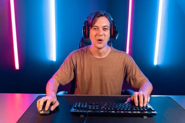 Kazanmak için çevrimiçi oyun oynayan akıllı flama makinesinin sunucu kanalı, neon ışıklı odada seçilen takım yarışması için izleyicilerle birlikte canlı yayında canlı yayında kulaklık takıyor. Bireysel.