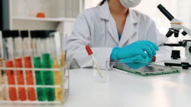 Laboratuvar kimya araştırmacısı mikroskop kullanarak yeni ilaç ya da tedavi geliştirir. Laboratuvar mikrobiyoloji ekipmanları ile bilimsel uzmanlık ile sağlık hizmetlerinin teknolojik gelişimi. Ağır çekim. Katı.