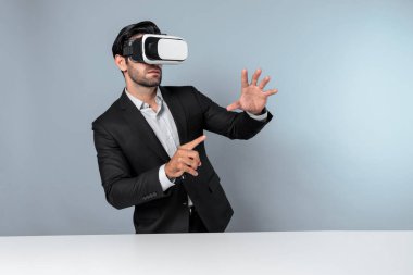 Akıllı yönetici veri analizine işaret ederken VR gözlüğü kullanarak veriye bakıyor. Beyaz yatırımcı takım elbise ve sanal gerçeklik kulaklığı takarken metaevreni birbirine bağlıyor. Yenilik teknolojisi. Sapma.