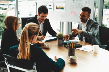 İş adamı yönetici, diğer iş adamları ve iş kadınlarıyla modern ofiste kahve fincanları ve belgelerle grup toplantısı yapıyor. Şirket çalışanlarının ortak çalışma konsepti. uds