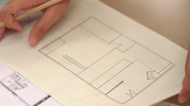 Akıllı mimar ya da akıllı mühendisin ölçüm aracı ve kalem el kullanarak mimari ofisindeki inşaat isabet planı üzerine detaylı bir yazı yazışının videosu. Eline odaklan. - Yakın çekim. Tanımlama.