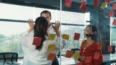 Mutlu iş adamları cam duvarda başarılı bir projeyi kutluyor. Profesyonel iş adamlarından oluşan bir grup el sıkışıyor, beşlik çakıyor, iş toplantısında başparmağını kaldırıyor. Yaratıcı iş. Yönlendirici.