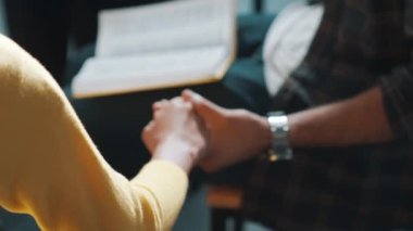 Çeşitli insanların el ele tutuşup İncil 'i kucağına alarak daireler çizmelerini istiyorum. Sadık duaların havadan görünüşü el ele tutuşup Tanrı 'ya inançla, inançla dua etmek. Sempozyum.