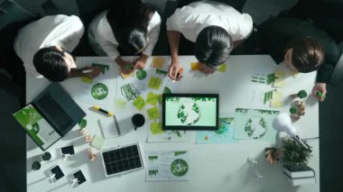 Yönetici yöneticisinin üst görünümü toplantılarda tablet temiz enerji gösterir. İş adamlarının sürdürülebilir çevre yatırımlarını planlamak ve yatırım yapmak için birlikte çalıştıklarına dair havadan bir bakış açısı. Hizalama.