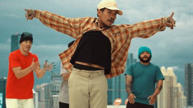 Çatıda çok kültürlü arkadaşlar varken profesyonel İspanyol break dansçısı B boy dansı. Genç modern dans grubu hip hop hareketi yapıyor. Tarz, moda, aksiyon. Açık hava sporu 2024 hiphop..
