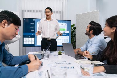 Proje yöneticisi monitörde proje yönetimi yazılım görüntülemesi, proje görevinin ilerlemesini izlemek ve toplantı masasında program planı yapmak suretiyle ekiple iletişim kurar ve işbirliği yapar. Tedbirli