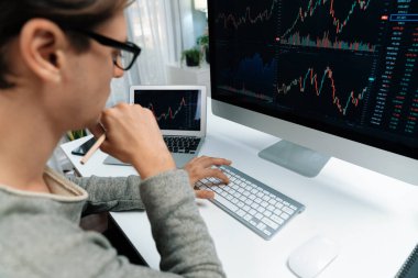 Bilgisayar ve dizüstü bilgisayarı kullanarak, çalışma masasındaki dinamik artırılmış borsa grafiğinin en yüksek kar değerini araştıran bir tüccar, modern ofisteki ekrandaki döviz kuru değerini analiz ediyor. Bireysel.