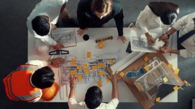 Yetenekli mühendis ekibinin proje planına bakarken konuştuğu en üst seviye görüntü. Birlikte çalışan ve mühendislik inşaatı için plan yapan bir grup akıllı iç mimar. Hizalama.