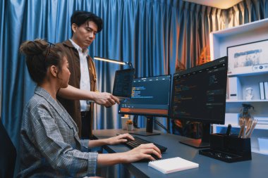 Modern ofisteki neon ışık odasında bilgi ağını gösteren dizüstü bilgisayarla iki ekranda veri çalıştıran akıllı web sitesi geliştirme kodlayıcı sistemini tartışan IT geliştiricilerinin ciddiyeti. İnfobahn.