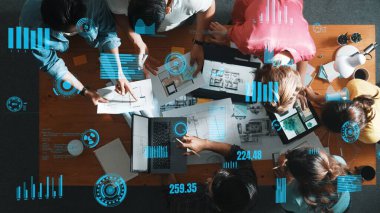 Sıradan giyinen, dizüstü bilgisayara bakan ve fikir paylaşan iş adamlarının en aşağıdan görünüşü. Yöneticinin hava görüntüsü çalışıyor ve masadaki renk paletini istatistiksel grafik hologramıyla kontrol ediyor. Sempozyum.