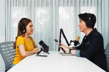 Gülümseyen radyo etkili sunucu elinde tablet, kulaklık takıyor kadın konuşmacı sosyal medya online canlı yayın kanalı ile röportaj yapıyor ve sabah stüdyo kaydında paylaşım linkini paylaşıyor. İnfobahn.