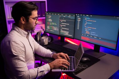 Akıllı IT geliştiricisi, yazılım kodlama sisteminde Neon Light ofis odasında yazı yazmak için çalışıyor, uygulama programı güncellemesi en son online web sitesi veritabanını çevrimiçi yapıyor. Tahmin et..