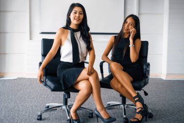 Ofiste oturan iki genç Asyalı iş kadını. İş arkadaşları ve toplum konsepti. uds