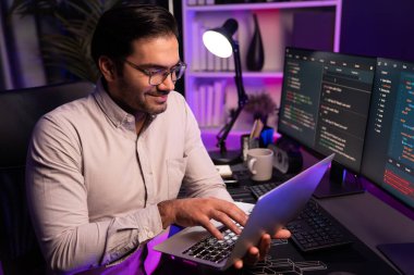 Akıllı IT geliştiricisi, yazılım kodlama sisteminde Neon Light ofis odasında yazı yazmak için çalışıyor, uygulama programı güncellemesi en son online web sitesi veritabanını çevrimiçi yapıyor. Tahmin et..