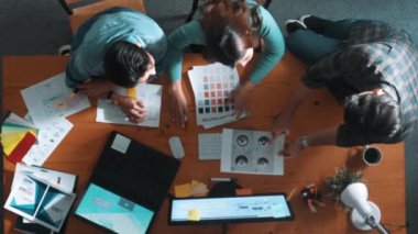 Ekip toplantısına katılıp fikir hakkında konuşurken proje yöneticisinin yazma fikrinin en üst görüntüsü. Renk paletine bakarken ve kağıda fikir yazarken profesyonel tasarımcı logosu. Sempozyum.