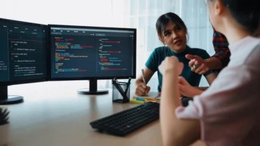 Yavaş çekim arkası yazılım geliştirici mühendisi bilgisayar programlama için birlikte çalışarak hata ayıklama kodunu çözüyor, ofiste monitörde karmaşık algoritmaları çözüyor. Filizlenen