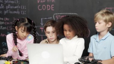 Çok kültürlü zeki çocuklar, BTMM teknoloji sınıfında hızlı yazılmış dizüstü bilgisayar programlama, yazma ya da kodlama programı kullanıyorlar. Dijital öğrenme konsepti. Etkinlik.