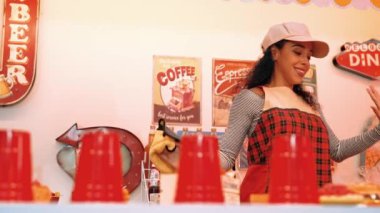 Profesyonel İspanyol restoran işçisi dans ediyor ve yemek barının arkasında duruyor. Kırmızı önlüklü çekici garson kameraya bakarken serbest stil müziğe geçiyor. Çılgın ve komik dans. Mutluluk.