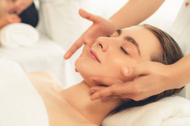 Kafkasyalı çift stres önleyici kafa masajının keyfini çıkarıyor ve lüks otellerde ya da otel spa salonlarında gündüz kaplıcalarında yüz güzelliği eğlencelerini şımartıyor. Sessiz.