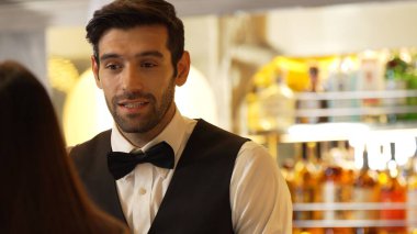 Gülümseyen zeki barmen, gece kulübünde VIP müşterilerle canlı sohbetler yapmak için güzel bir gece partisi atmosferine mükemmel bir servis sunuyor. Vinosity.