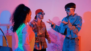 İspanyol hipster renkli kıyafetler giyer ve serbest stil müziğe el sallar. Profesyonel break dansçı neon ışıklarıyla ve modern stüdyo arkadaşlarıyla coşkuyla dans ediyor. Mutluluk.