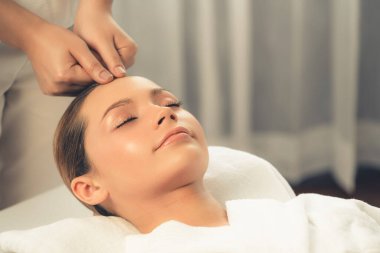 Kafkasyalı kadın stres önleyici kafa masajından ve lüks tatil beldesi ya da otel spa salonundaki modern ışık ortamında yüz güzelliği eğlencelerini şımartmaktan hoşlanıyor. Sessiz.