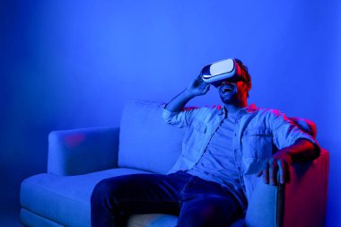 Komik film izlemek için VR gözlük takan mutlu bir adam. Beyaz insan, sanal ya da metaevrensel sanal dünyaya bakarken VR teknolojisiyle yenilik yaparak rahatladı. Sapma.