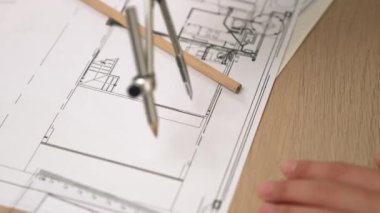 Bölücü araç ve el yazısı kullanan akıllı mimar ya da güvenlik mühendisinin videosu mimari ofisteki inşaat doğruluğu planının ayrıntılarını içeriyor. Eline odaklan. - Yakın çekim. Tanımlama.
