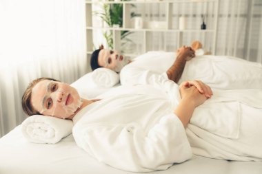 Kaplıca salonunun sakin, modern gündüz atmosferi, birkaç müşteri yüz maskesi takarak kendini yenilemeye çalışıyor. Yüz bakımı ve güzellik kozmetolojisi prosedürü. Sessiz.