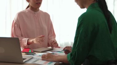 Yavaş çekim iki tasarımcı beyin fırtınası yapıyor ve grafik tasarımı için renk seçiyor ya da istemci renk bozukluklarını tasarımcı bürosundaki kromatik konsültasyonla karşılaştırıyor. Değiştirilmiş