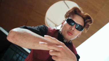 Kameraya poz veren modern dansçı ve düşük açılı kamera. Hip hop tarzında dans eden genç hip hop dansçısının portresi. Açık hava sporu 2024. Hareket atışı. Serbest stil. hiphop.