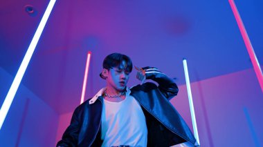 Profesyonel sokak dansçısının sıradan kıyafetlerle kameraya baktığı alçak açılı kamera. Stüdyoda mor ışık altında dururken şehirde pop müzik yapan yetenekli bir sanatçı. Kapatın. Mutluluk.