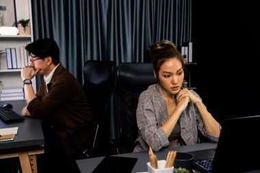 Modern ofiste gece geç saatlerde arka tarafta çalışan iş arkadaşı ile birlikte veri analizi sosyal medya çevrimiçi proje işini rapor etmek için bilgisayara odaklanan iş kadınının ciddi yüzü. İnfobahn.