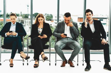 İş kadınları ve işadamları iş görüşmesi için koltuklarda beklerken cep telefonu kullanıyorlar. Şirket işi ve insan kaynakları kavramı. uds