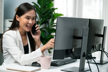 Çalışan Asyalı genç iş kadını müşteriyi arıyor. Kanal satış hedefleri için sosyal web sitesinde analiz etmek üzere çevrimiçi pazarlama stratejisi reklamları sunuyor. Taktik.