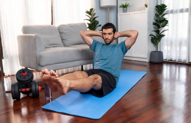 Atletik ve sporcu adam, evde vücut egzersizi yaparken spor ve spor yaşam tarzına uyum sağlamak için spor minderinde çatırdıyor. Gaiety ev egzersizi antrenman konsepti.