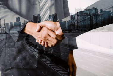 İş adamlarının arka plandaki belediye binasında el sıkışması ortaklık anlaşmasının başarısını gösteriyor. Kurumsal takım çalışması, güven ortağı ve iş anlaşması kavramı. uds