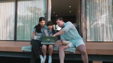 Şirin baba, anne ve kızı birlikte evin bahçesinde oturuyorlar. Ebeveynler, çevre farkındalığıyla ilgili genç nesli iletişim kurmak için açık hava aktivitelerini kullanırlar. Uyumsuzluk.