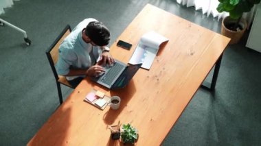 Finans tablosuna bakarken, iş adamının dizüstü bilgisayarla çalışmasının en üst görüntüsü. Toplantı masasında oturmuş bilgisayar kullanarak ekrana bakarken verileri analiz eden sıradan bir bez yöneticisi. Cemaat.