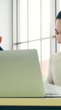 Modern ofis odasındaki masada çalışan iş adamları mali veri raporlarını incelerken .