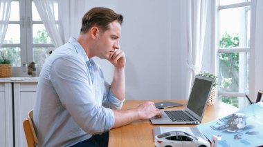 Araç tasarım mühendisi ev ofisindeki otomobil işi için prototip üzerinde çalışıyor. Otomotiv mühendisliği tasarımcısı dikkatlice analiz eder, kusurları bulur ve araba tasarımında gelişmeler kaydeder. Eşzamanlama