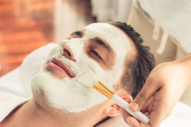 Kaplıca salonunun sakin atmosferi, insan müşterisi modern gün ışığında lüks yüz kremi masajıyla kendini yenileme zevkine kapılıyor. Yüz bakımı ve güzellik konsepti. Sessiz.