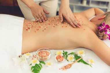 Lüks spa salonlarında sıcak mum ışığında cilt bakımı yaptıran kadın müşteri. Sağlık Spa vücut fırçasında tuz temizleme güzellik tedavisi. Sessiz.